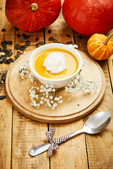 fresh and delicious pumpkin soup on an old wooden kitchen table