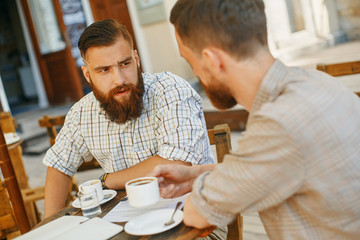 Obraz premium dwóch mężczyzn pije kawę w kawiarni