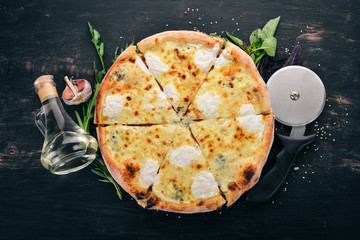 PIZZA QUATTRO FORMAGGI. Italian cuisine. On a wooden background. Free space for text. Top view.