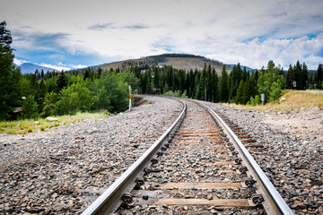 Fototapeta premium View down the railway tracks onto a forest
