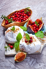Mini pavlova cake with figs, cranberries and mint leaves