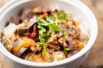 Northern Thai food (Kanom Jeen Nam Ngeaw) with vegetables on wooden background,spicy rice noodles soup