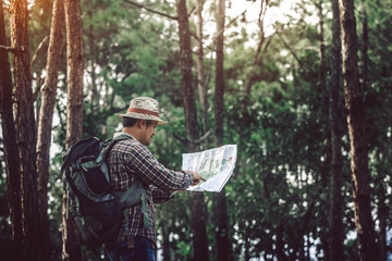 hiker look at map and checking in the forest