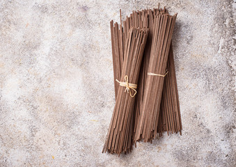 Raw uncooked Japanese soba noodles on light bacground