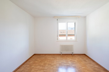 Empty room with window and parquet