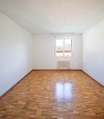 Empty room with window and parquet