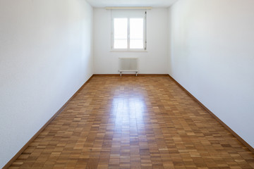 Empty room with window and parquet