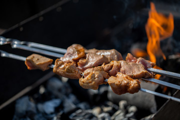 closeup of some meat skewers being grilled in a barbecue