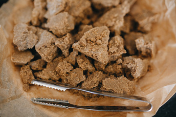 Pieces of sweet halva with peanuts, nuts in a glass bowl.