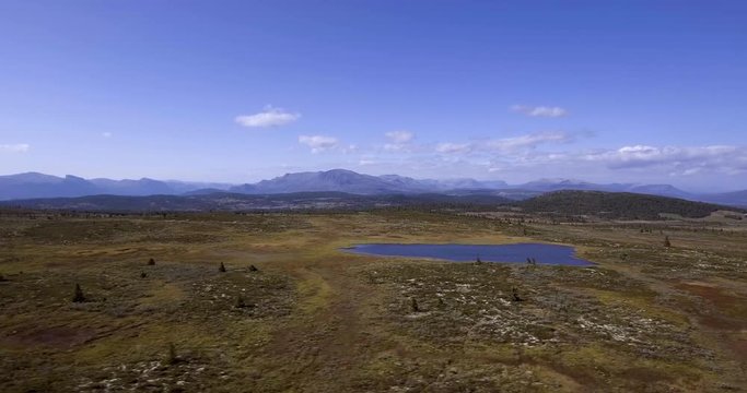Right sliding aerial drone shot from Golsfjellet, a mountain located in Hallingdal, Norway. Nice little lake in the foreground.