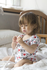 Fototapeta premium Baby girl, 20 months, Necklace, pearls, Bedroom, duvet, pillow, cot, Barefoot, Bodysuit, window,