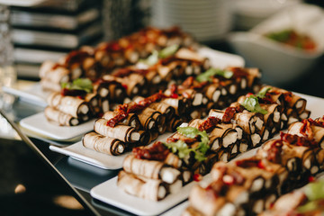 Rustic fried eggplant with cheese and meat, decorated with pomegranates, tomatoes and white plate sauce.