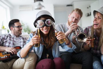 Happy group of friends playing instruments and partying