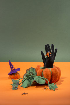 Still life with handmade pumpkins from felted wool and a glove for the celebration of Halloween