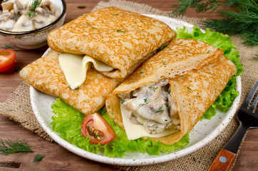 Pancakes stuffed with mushrooms and cheese with cream sauce