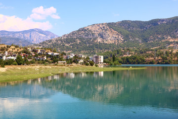 Fototapeta na wymiar landscape with a lake and a village in the mountains on a sunny day