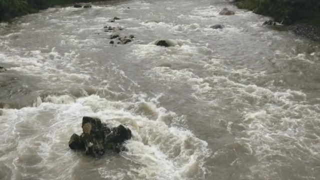 Aerial slow motion shot of a river in flood. The Rio Abanico on the Amazonian slopes of the Andes, Morona Santiago province, Ecuador, after heavy rain.