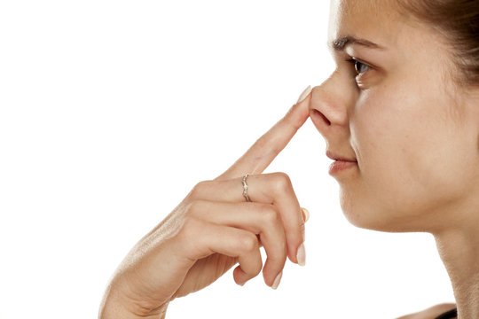 Profile of young woman lifting her nose on white background