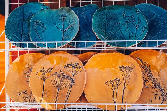 Souvenir shop with ceramic plates. Showcase with hand-made products. Dishes with floral ornaments