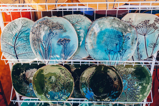 Souvenir shop with ceramic plates. Showcase with hand-made products. Dishes with floral ornaments