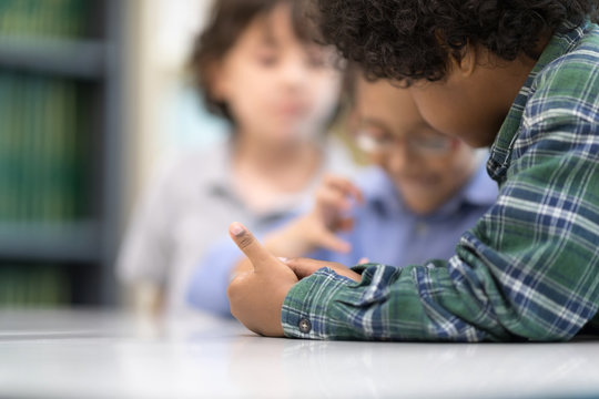 Selective focus at left hand little boys watching Phone. Happy Children Learning Class in Library. Development of Human Resources in Education Concept. Setup studio shooting. - Powered by Adobe