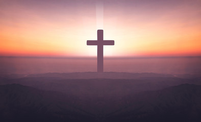 Silhouette of crucifix cross on mountain at sunset time with holy and light background.