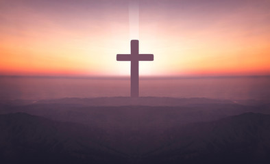 Silhouette of crucifix cross on mountain at sunset time with holy and light background.
