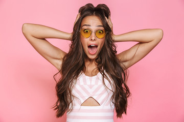 Photo of gorgeous woman 20s wearing sunglasses rejoicing with surprise and screaming, isolated over...