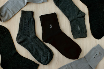 Socks for men. Many men's socks are scattered on the table. View from above. Gray and black socks are clothes for men.