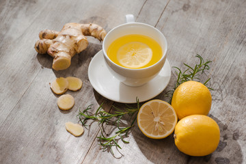 Cup of Ginger tea with lemon. Cup of Ginger tea with lemon. Glass mug of green hot tea on wooden table. Sliced lemons on a chopping board