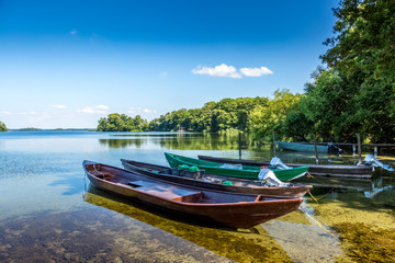 Boote liegen im ruhigen Wasser am See