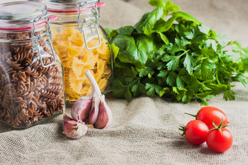 Different pasta in glass jars - basil of garlic and cherry