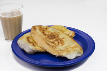 Popular Brazilian bread with melted butter called pão na chapa and a cup of hot coffee mixed with milk called média or pingado found in any bakery in white background