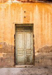 Fototapeta na wymiar Weathered door, on rusty painted wall.