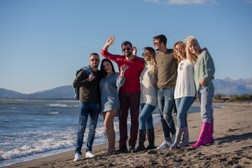 portrait of friends having fun on beach during autumn day