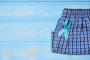Prostate Cancer Awareness, light Blue Ribbon with male underpants on blue wooden background for...