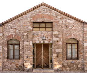 Fototapeta na wymiar Old stone building with wooden door and two windows with bars.