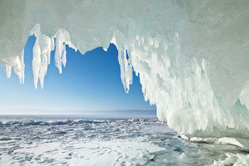 Baikal Lake in winter season. Many icicles in the arch of the ice grotto in the coastal rocks of Olkhon Island. Natural cold background