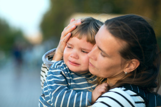 The Child Cries On Hands At Mother On Walk