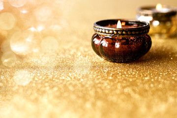 Candlelights on golden glittering background