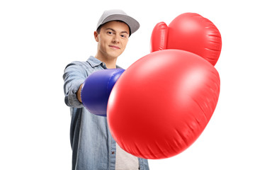 Teenage boy wearing a pair of big boxing gloves