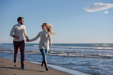 Fototapeta na wymiar Loving young couple on a beach at autumn sunny day