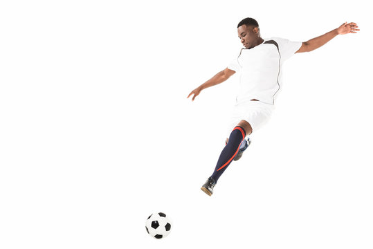 young african american soccer player kicking ball in jump isolated on white - Powered by Adobe