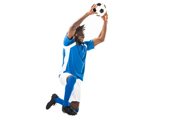 Fototapeta na wymiar happy african american sportsman kneeling and holding soccer ball isolated on white