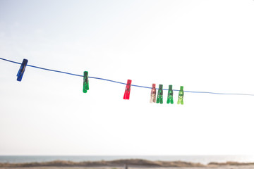 multicolored clothespins on a leash outdoors on the sky background