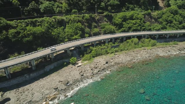 Aerial view of Patapat viaduct in the coast of Pagudpud, Ilocos Norte. Highway with bridge by coast sea near the mountains. Philippines, Luzon.
