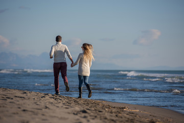 Loving young couple on a beach at autumn sunny day