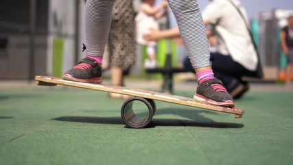 life in a modern city - a girl rides a balance-board on an advanced playground