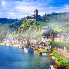 Cochem medieval town Reichsburg castle view across Mosel river Germany. Scenic panoramic landscape of historic German village hill fortress, water reflection and vineyards. © Freesurf