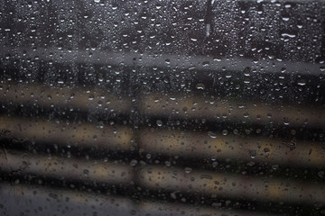 Window view blurry with heavy rain, natural raindrops on glass